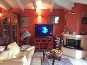 sala de estar con TV y chimenea en B&B Villa Gardasee With Pool, en Soiano del Lago