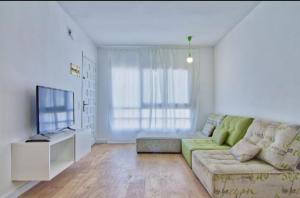 sala de estar con sofá verde y TV en Casa Antoniet de la llum, en Riumar