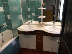 a bathroom with two sinks and a bath tub at Chambre Rose in Bastia