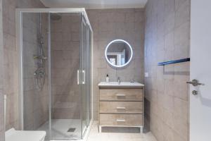 uma casa de banho com um chuveiro, um lavatório e um espelho. em Apt with Antique Floor & lots of Sun Light em Valência