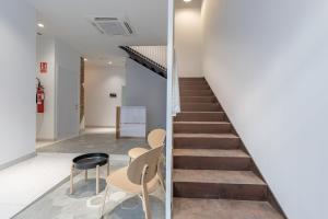 a staircase in a room with two chairs and a table at Apt with Antique Floor & lots of Sun Light in Valencia