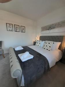 ein Schlafzimmer mit einem großen Bett mit zwei weißen Kissen in der Unterkunft Doctors lane Stylish 3 Bedroom Family House with Parking in Melton Mowbray