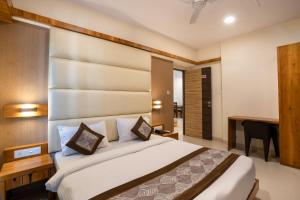 a bedroom with a large bed and a desk at Home2 Suites and Service Apartments, Mumbai Airport in Mumbai