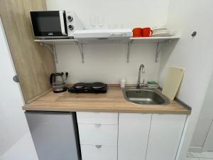 una pequeña cocina con fregadero y microondas en Апартаменты #3, en Almaty