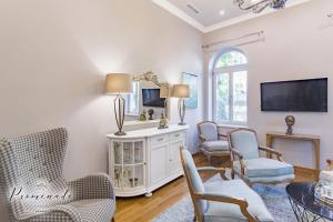 a living room with chairs and a tv on a wall at Villa Promenade in Burgas City