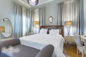 a bedroom with a bed and a chair and a mirror at Villa Promenade in Burgas City