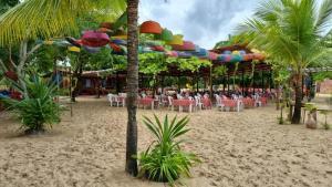 a beach with tables and chairs on the sand at Itaparica - Vera Cruz 12 pessoas in Vera Cruz de Itaparica