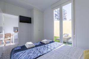 a white bedroom with a bed with towels on it at Marvellous Apt with a Large Private Terrace in Valencia