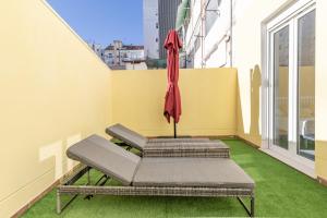 Marvellous Apt with a Large Private Terrace في فالنسيا: فناء فيه مظلة وكرسي على شرفة