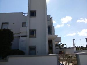 a white building with a fence in front of it at Le Dimore di Otranto - Altomare in Otranto +4 photos