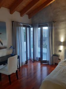 1 dormitorio con cama, escritorio y ventana en Il giardino di Pietro, en Monza