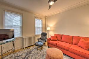 a living room with a red couch and a television at Lancaster Townhome Walk to Central Market! in Lancaster