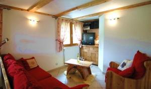 a living room with a red couch and a table at Appart 4 pers proximité lac et remontées Le Praz - Arrayanes in Courchevel