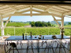 una mesa y sillas en un patio con vistas en Magnifique villa plain pied avec piscine en Fronsac