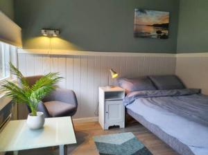 a bedroom with a bed and a chair and a table at Varangertunet Rooms and Apartments in Jakobselv