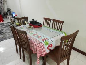 a dining room table with a red and white table cloth at Jeram Staycation in Jeram