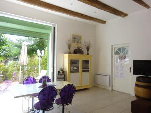 a dining room with a table and purple chairs at Gîtes "tout au sud de la France" in Pomérols