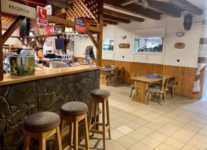 a bar in a restaurant with tables and stools at Ranč pod Babicou in Bojná