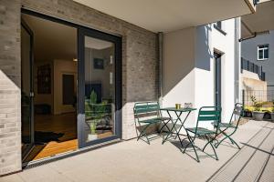 eine Terrasse mit Stühlen und einem Tisch auf dem Balkon in der Unterkunft Moderne Neubauwohnung bei Köln in Lindlar