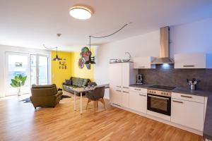 eine Küche mit weißen Schränken und ein Wohnzimmer in der Unterkunft Moderne Neubauwohnung bei Köln in Lindlar