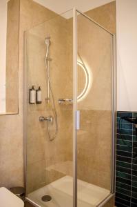 a shower with a glass door in a bathroom at HOMELY STAY Studio 5 in Munich