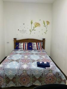 a bedroom with a bed with a quilt on it at La Fortuna Roja in San José