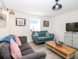 a living room with a couch and a tv at Seaspray Cottage in Buckie