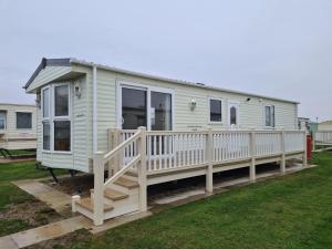 a mobile home with a porch and a deck at 6 Berth central heated on The Chase Roxburgh FREE WIFI in Ingoldmells