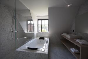 un bagno con vasca, doccia e lavandino di Hotel De Lissewal a Ypres