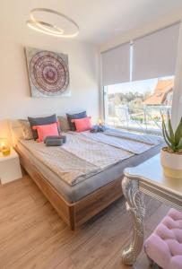 un grande letto in una stanza con una grande finestra di Lelle Marine Resort Voila Apartman a Balatonlelle