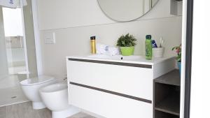 a bathroom with a white sink and a toilet at Zero5.Zero5 in Lignano Sabbiadoro