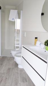 a white bathroom with two toilets and a sink at Zero5.Zero5 in Lignano Sabbiadoro
