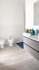 a white bathroom with a sink and a toilet at Zero5.Zero5 in Lignano Sabbiadoro