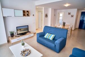 a living room with a blue couch and a table at Magnifico Apartamento Edificio Marina in Calafat