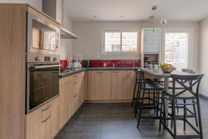 una cocina con armarios de madera y una mesa con taburetes. en BISLAYNE, en Saint-Malo