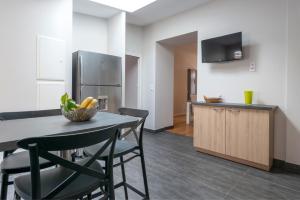 a kitchen with a table and chairs and a refrigerator at BISLAYNE in Saint Malo