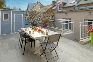 a patio with a table and chairs on a balcony at BISLAYNE in Saint Malo