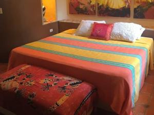 two beds with colorful blankets and pillows in a room at Villas Jardin Del Mar in Cruz de Huanacaxtle