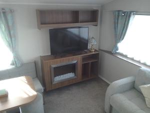 a living room with a flat screen tv and a couch at 54 Apple Grove in Exmouth