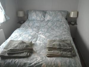 a bed with two towels on it with two lamps at 54 Apple Grove in Exmouth