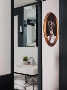 a bathroom with a dog in a mirror at Maisons du Monde Hotel & Suites - Nantes in Nantes