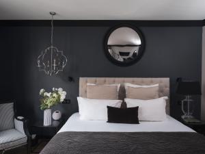 - une chambre avec un grand lit et un miroir dans l'établissement Maisons du Monde Hotel & Suites - Nantes, à Nantes