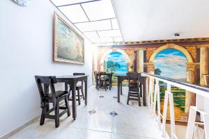 uma sala de jantar com mesas e cadeiras e um quadro na parede em Ayenda Imperio la 16 em Pereira