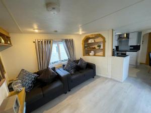 a living room with a couch and a kitchen at Reighton Sands 1 in Filey