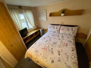 a bedroom with a bed and a television in it at Reighton Sands 1 in Filey