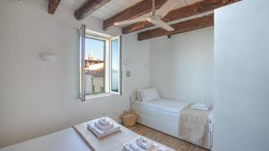 Habitación pequeña con cama y ventana en Welcomely - Waterfront home a balcony on the sea, en Alghero