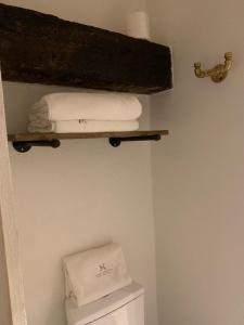 2 asciugamani su una mensola sopra i servizi igienici in bagno di Casa Martha hotel boutique a Tequisquiapan