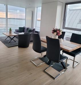 uma sala de estar com uma mesa e cadeiras e um sofá em schwimmende Ferienwohnung Rooftop em Elsterheide