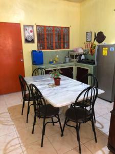 a kitchen with a table with four chairs and a kitchen with auclear at 15pax-2minutes to Vigan-Rose and Fer Transient-2 Bedroom House in Bantay