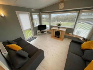 a living room with a couch and a television at Reighton Sands 2 in Filey
